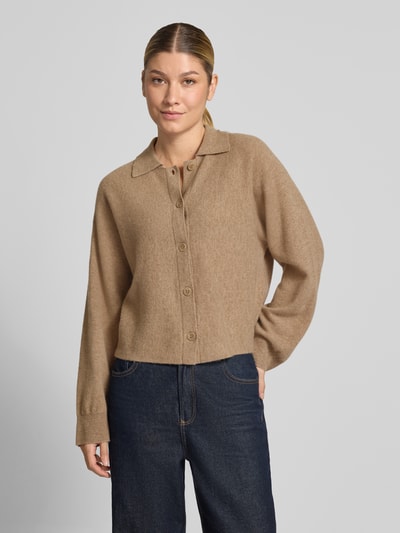 Frauenmodel trägt Regular Fit Strickjacke aus reiner Wolle Modell 'Dulena' von OPUS in Beige zu Jeans, Ganzkörperansicht von vorne. Damen Pullover