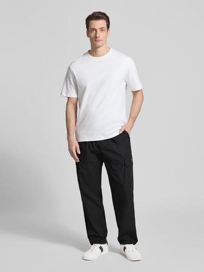 Männermodel trägt Regular Fit Hose mit Cargotaschen Modell 'LOGAN' von Antony Morato, schwarzer Baumwoll-Mix, Ganzkörperansicht von vorne.