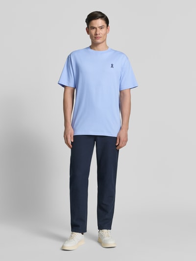 Männermodel trägt Relaxed Fit T-Shirt aus reiner Baumwolle Modell 'MAARKOS' von Armedangels in Optik: Unifarben mit Label-Patch, Logo-Print, Rundhals, Ärmelform: Kurzarm, Materialverarbeitung: Jersey, Herren T-Shirt; Ganzkörperansicht von vorne.
