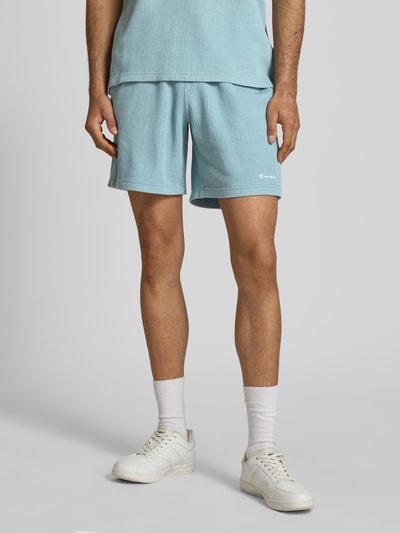 Männermodel trägt Shorts mit Strukturmuster und elastischem Bund von CHAMPION, hellblau, Baumwoll-Mix, Regular Fit, Nahaufnahme Oberschenkel.