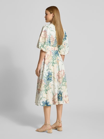 Frauenmodel trägt Midikleid aus Leinen-Mix mit floralem Allover-Print von Ted Baker, lockere Passform, bunte Blumen, Halbarm, Stoffgürtel, Ganzkörperansicht Rückansicht.