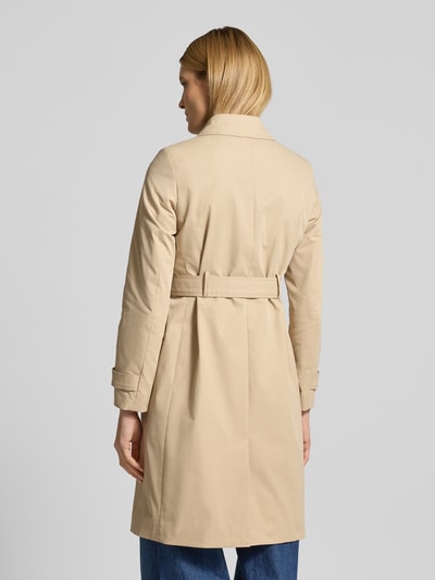 Frauenmodel trägt Trenchcoat mit Ärmelriegeln von Christian Berg Woman Selection in Beige, strukturierte Baumwoll-Optik, Ganzkörperansicht Rückansicht, taillierte Passform, doppelreihige Knopfleiste, Taillengürtel, Rückenlänge 100 cm, Schulterbreite 39 cm, Brustweite 48 cm, Ärmellänge 63 cm.