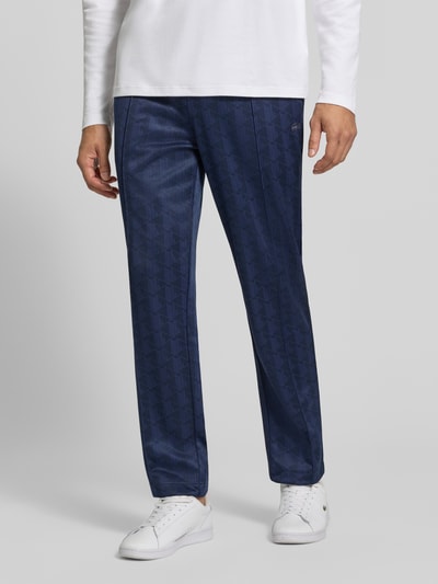 Männermodel trägt eine dunkelblaue Regular Fit Sweathose aus mit Logo-Print von Lacoste, feine Struktur, Herren Sweathose, Ganzkörperansicht von vorne.