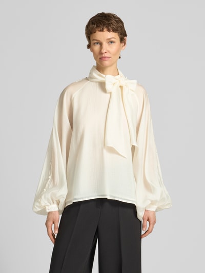 Frauenmodel trägt Blusenshirt aus Lyocell-Mix mit Schal von Copenhagen Muse, cremefarben, lockere Passform, Knöpfe, Ganzkörperansicht von vorne.