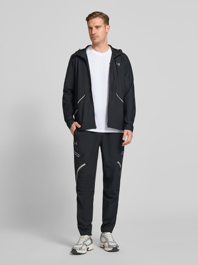Männermodel trägt Regular Fit Sweatpants mit Logo-Print Modell 'Unstoppable' von Under Armour, Schwarz, Elastischer-Material-Mix, Cargo-Taschen mit Reißverschluss, Bund, Herren, Ganzkörperansicht von vorne.