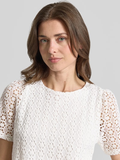 Kobiece modelka nosi Regular Fit T-Shirt in Strick-Optik od More & More, wzór kwiatowy, krój regular fit, półprzezroczysta bawełniana mieszanka, krótki rękaw, okrągły dekolt, kolor biały, tekstura dzianiny, widok z przodu, zbliżenie na górną część ciała.
