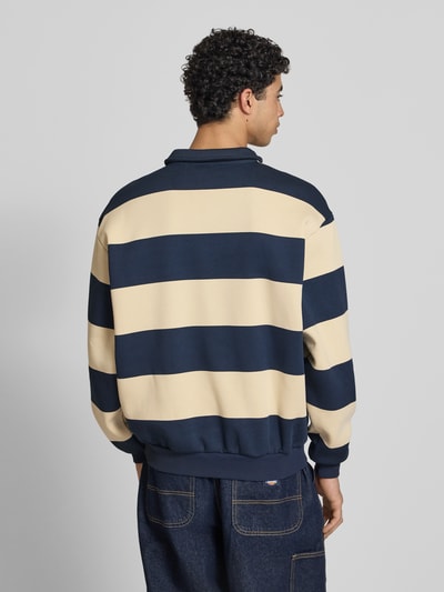 Männermodel trägt Oversized Sweatshirt mit Polokragen Modell 'Heritage' von KARL KANI im Oversized-Fit, Baumwoll-Mix, Rückenlänge 65 cm, Rückenansicht.