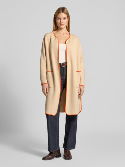 Frauenmodel trägt Strickmantel aus Baumwoll-Kaschmir-Mix mit aufgesetzten Taschen von HERZENS, Relaxed-Fit, offene Passform, beige mit orangefarbener Umrandung, Rückenlänge 99 cm, Ärmellänge 57 cm, Damen, Ganzkörperansicht von vorne.