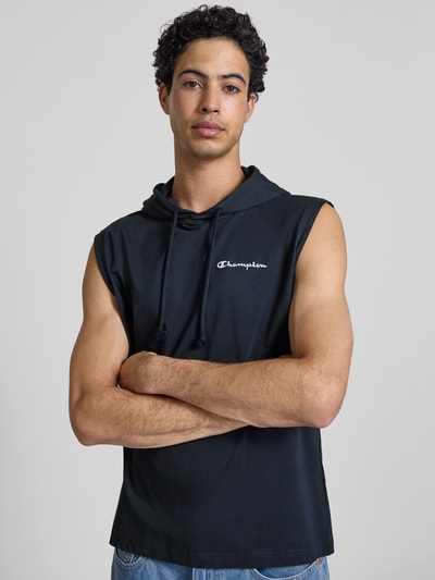 Männermodel trägt Hoodie mit Label-Stitching von CHAMPION in Schwarz, Reine Baumwolle, Regular-Fit, Kapuze mit Tunnelzug, Nahaufnahme Oberkörper.