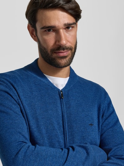 Männermodel trägt Cardigan aus Wolle-Kaschmir-Mix mit Reißverschluss von Fynch-Hatton, krój regular fit, stójka, wyhaftowane logo, Długość tyłu w rozmiarze M: 68 cm, Długość rękawów w rozmiarze M: 66 cm, kolor niebieski, dzianina o miękkiej fakturze, Nahaufnahme Oberkörper.