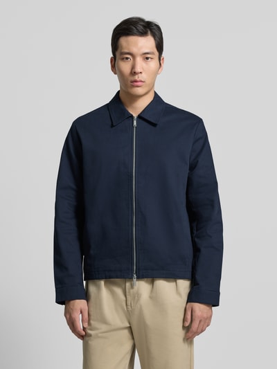 Männermodel trägt Regular Fit Blouson mit Reißverschluss Modell 'DOBBY' von CK Calvin Klein in Dunkelblau mit Umlegekragen, Ganzkörperansicht von vorne.