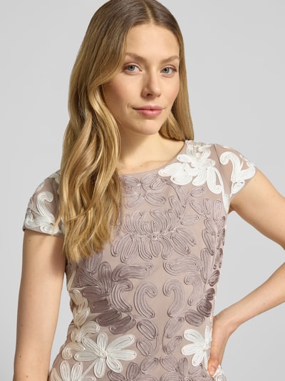 Frauenmodel trägt Knielanges Cocktailkleid mit Kappärmeln von Christian Berg Cocktail, Elastischer-Material-Mix, Rundhalsausschnitt, Nahaufnahme Oberkörper.