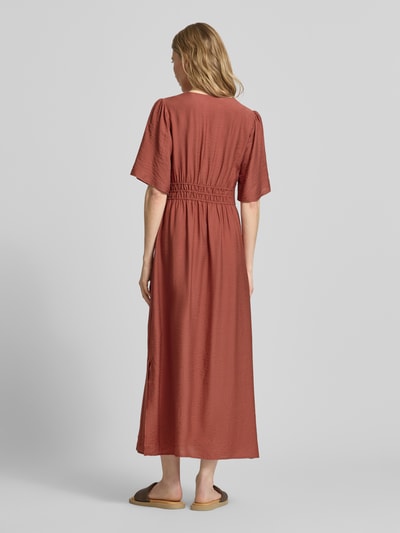 Frauenmodel trägt Maxikleid aus Viskose-Mix mit V-Ausschnitt Modell 'Iggy' von B.Young in Braun, Falten-Optik, Ganzkörperansicht Rückansicht. Damen Maxikleid, taillierte Passform, Halbarm, Rückenlänge 131 cm, Brustweite 34 cm, Ärmellänge 31 cm.