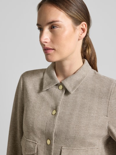 Frauenmodel trägt Regular Fit Hemdjacke mit Viskose-Anteil von s.Oliver BLACK LABEL in Beige mit feinem Zickzackmuster, Nahaufnahme Oberkörper.
