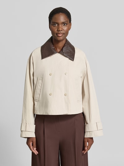 Kobiece modelka nosi Jacke mit Ärmelriegeln Modell 'AVANTI' od YAS, bawełniana mieszanka, krój regular fit, dwurzędowa, kołnierz wykładany, kieszenie ukośne, długość tyłu w rozmiarze 36: 57 cm, szerokość ramion w rozmiarze 36: 54 cm, szerokość w biuście w rozmiarze 36: 58 cm, długość rękawa w rozmiarze 36: 57 cm, jasny beż z brązowym kołnierzem, widok sylwetki od przodu
