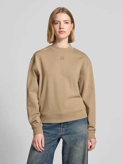 Frauenmodel trägt Regular Fit Sweatshirt aus reiner Baumwolle Modell 'DAXANDRIA' von HUGO in Beige, unifarben, Logo-Stitching, Ganzkörperansicht von vorne.