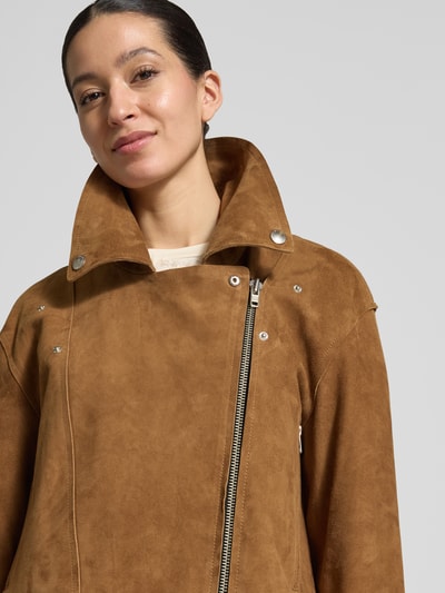 Frauenmodel trägt Lederjacke mit Reverskragen Modell 'Kaia' von STAND STUDIO aus Ziegenvelours in Braun mit Reißverschluss, Nahaufnahme Oberkörper. Damenjacke, Gerader-Schnitt, Rückenlänge 50 cm, Schulterbreite 45 cm, Brustweite 58 cm, Ärmellänge 67 cm, Größe 36.