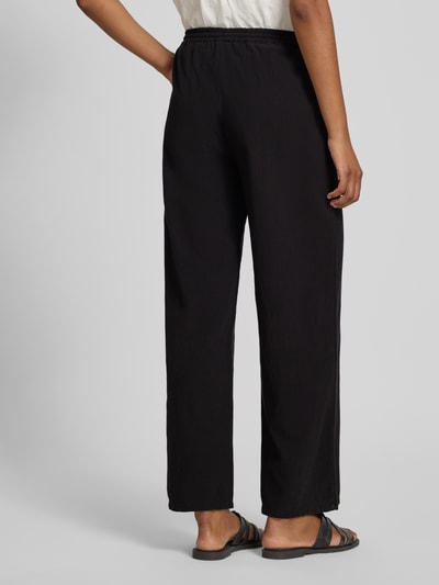 Frauenmodel trägt schwarze Stoffhose in verkürzter Passform Modell 'CISSIE' von Soyaconcept aus reiner Baumwolle mit elastischem Bund und Tunnelzug, Wide Leg, Ganzkörperansicht Rückansicht.