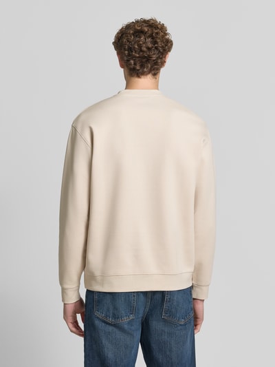 Männermodel trägt slim fit pullover uit pure katoen 'TOM' van Selected, effen beige, zachte textuur, heren sweatshirt, volledig lichaam achteraanzicht
