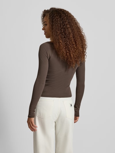 Vrouwenmodel draagt bruin shirt met lange mouwen van Model 'MAYA' van NOISY MAY®, mix van katoen en elastaan, slim fit, riblook, met kant, knoopsluiting, ruglengte maat S 51 cm, volledig beeld achterkant.
