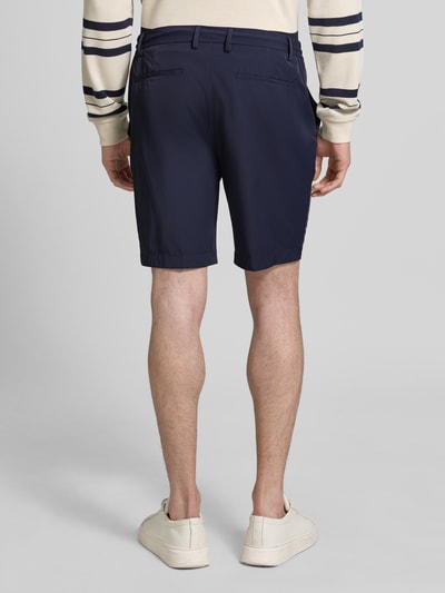 Männermodel trägt Pantalaccio Fit Bermudas mit Eingrifftaschen von MARKUP in Dunkelblau, Material-Mix mit Stretch-Anteil, Paspeltaschen am Gesäß, Bundweite 41 cm, Innenbeinlänge 21 cm, Ganzkörperansicht Rückansicht.