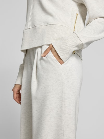 Kobiece modelka nosi Wide Leg Pants aus Viskose-Mix mit elastischem Bund od VARLEY, kremowy kolor, tekstura miękka, boczne kieszenie, szerokość w rozmiarze S 36 cm, długość nogawki 84 cm, krój rozszerzany, widok z przodu, zbliżenie na biodra.