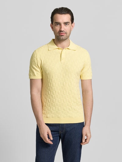 Männermodel trägt Regular Fit Poloshirt mit Strukturmuster von MCNEAL in Gelb, reine Baumwolle, Polokragen, Strick-Optik, Ganzkörperansicht von vorne.
