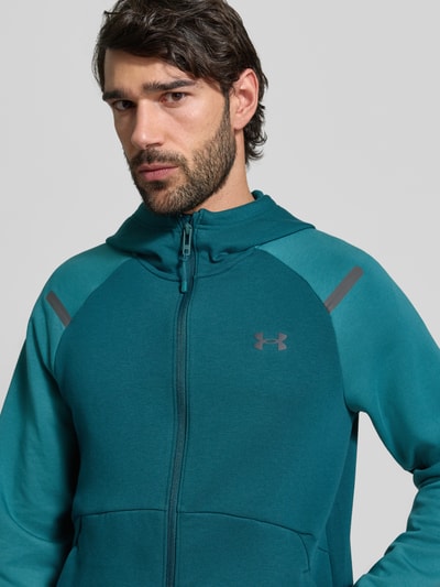 Männermodel trägt Regular Fit Jacke mit Kapuze Modell 'Unstoppable' von Under Armour, Elastischer-Material-Mix, Logo-Print, Nahaufnahme Oberkörper.