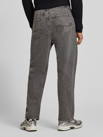 Męski model nosi szare jeansy Baggy Jeans im 5-Pocket-Design Model 'ALEX' od JACK & JONES z bawełny, 5 kieszeni, zapięcie na guzik i zamek błyskawiczny, Szerokość w rozmiarze 32/32: 42 cm, Długość wewnętrzna nogawki w rozmiarze 32/32: 74 cm, widok całej sylwetki od tyłu.