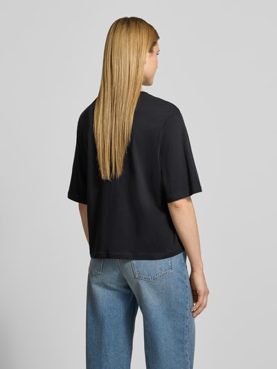 Frauenmodel trägt Boxy Fit T-Shirt aus Bio-Baumwolle Modell 'Derby' von Soyaconcept, schwarze Farbe, Rückenlänge bei Größe S 57 cm, Ganzkörperansicht Rückansicht.