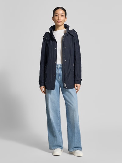 Frauenmodel trägt Regular Fit Jacke mit Logo-Print von Fuchs Schmitt in Dunkelblau, Stehkragen, Kapuze, Reißverschlusstaschen, Ganzkörperansicht von vorne.