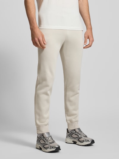 Männermodel trägt Sweatpants mit elastischem Bund und Label-Stitching von CHAMPION aus Baumwoll-Mix, Regular-Fit, Ganzkörperansicht von vorne.