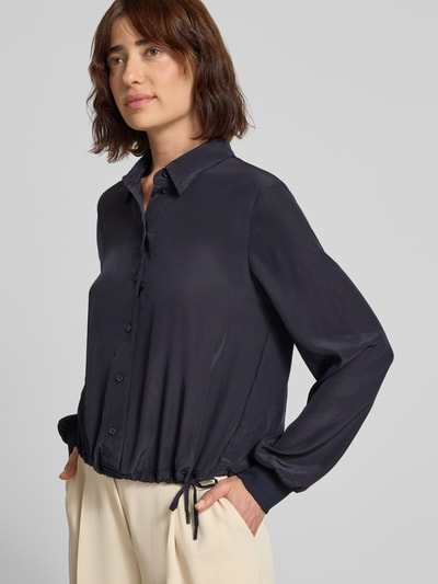 Frauenmodel trägt Regular Fit Bluse mit Tunnelzug von Marc Cain in Dunkelblau, Hemdblusenkragen, Knopfleiste, glatte Textur, Nahaufnahme Oberkörper. Rückenlänge 56 cm, Ärmellänge 63 cm.