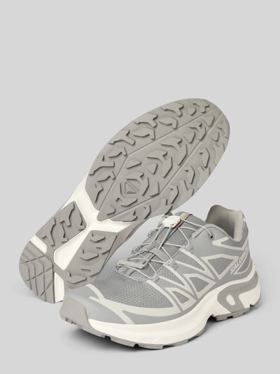Produktfoto, Sneaker mit profilierter Sohle Modell 'XT-EVR' von Salomon in Grau mit abgerundeter Spitze, Schnürung und Logo auf hellem Hintergrund