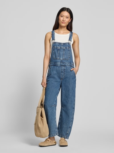 Vrouwenmodel draagt 'Barrel Fit Denim-Latzhose met verstelbare bandjes' van GAP, puur katoen, barrel fit, denim, borstzak, totale lengte 146 cm, binnenbeenlengte 66 cm, ruglengte 47 cm, borstwijdte 42 cm, vooraanzicht volledige lichaamsopname