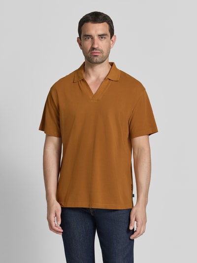 Männermodel trägt Relaxed Fit Poloshirt in Pique-Optik von Scotch & Soda, Reine Baumwolle, Polokragen, Kurzärmelig, braun, Ganzkörperansicht von vorne.