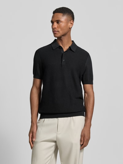 Männermodel trägt Regular Fit Poloshirt aus reiner Baumwolle von Strellson in Schwarz mit Strickoptik, kurzarm, Ganzkörperansicht von vorne.