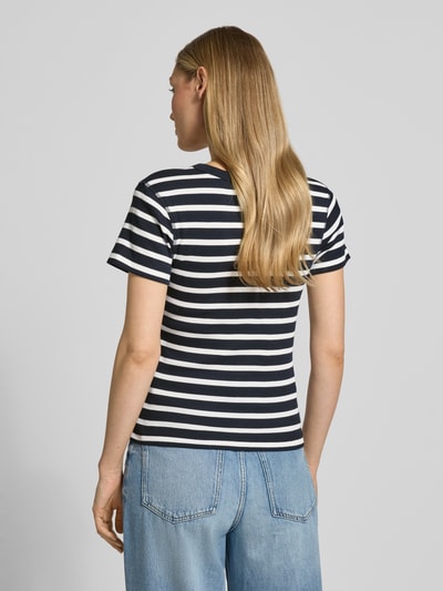 Kobiece model prezentuje damski t-shirt z bawełny Drykorn, dopasowany krój, drobne prążkowanie, okrągły dekolt, model 'KOALE', długość tyłu w rozmiarze S: 52 cm, widok całej sylwetki od tyłu.