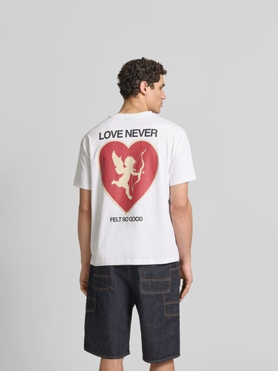 Männermodel trägt Relaxed Fit T-Shirt aus reiner Baumwolle von Don’t Waste Culture mit Label-Print, Weiß, ganzkörperansicht Rückansicht. Herren T-Shirt, Rundhalsausschnitt, kurzärmelig, Rückenlänge bei Größe M 68 cm.