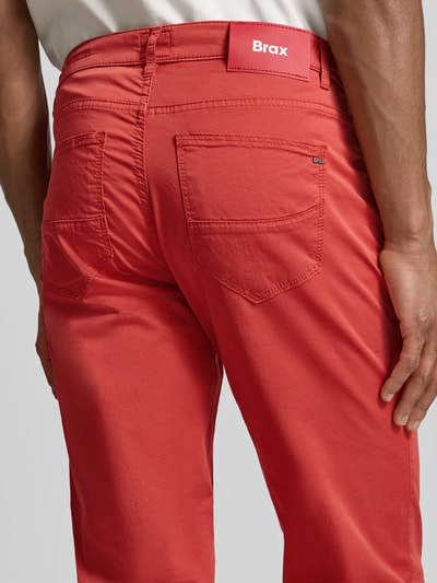 Mężczyzna nosi Slim Fit Stoffhose mit Lyocell-Anteil Modell 'Cadiz' od Brax w kolorze koralowym, 5 kieszeni, materiał elastyczny, zdjęcie całych pleców