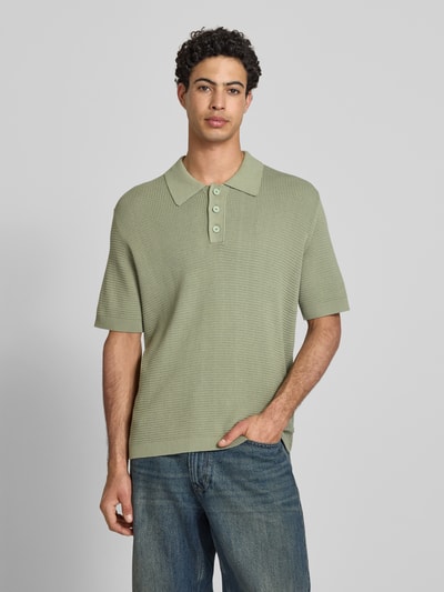 Mannenmodel draagt Regular Fit poloshirt uit puur katoen van Marc O'Polo Denim in effen kleuren, grofgebreide textuur, V-hals, labelpatch, polokraag, knoopsluiting, korte mouw, geribde mouwboord en rompzoom, ganzekopie van voren.
