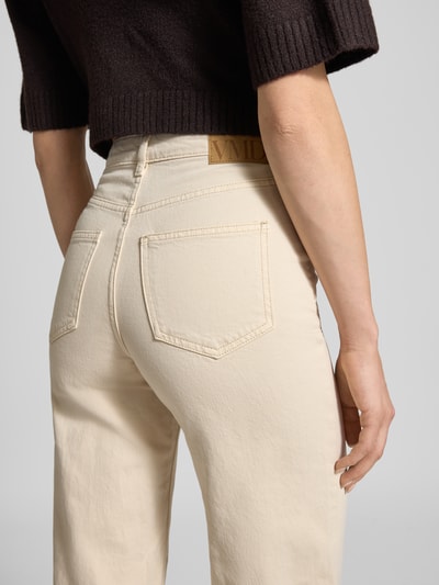 Vrouwenmodel draagt Wide Leg Loose fit Jeans uit katoenmix model 'Tessa' van Vero Moda, look: effen, detailopname rug. Context: dames loose fit jeans, model 'Tessa', look: effen kleuren, pasvorm: loose fit, taille: high waist, applicatie: labelpatch, details: riemlussen, sluiting: knoop en verborgen ritssluiting, zakken: 5-pocketmodel, materiaalverwerking: denim, materiaal: katoenmix.