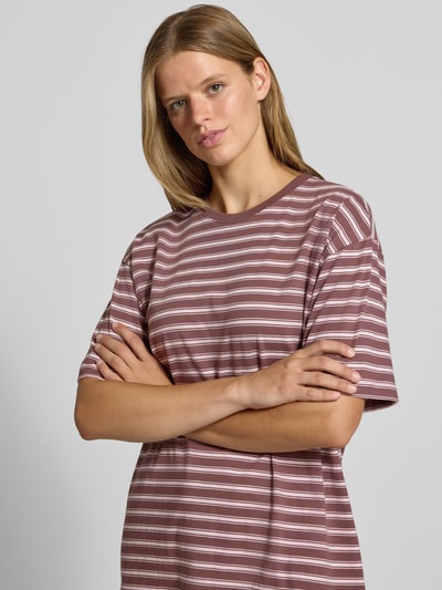 Frauenmodel trägt T-Shirt von REVIEW in Braun mit weißen Streifen, reine Baumwolle, lockerer Schnitt, Nahaufnahme Oberkörper.