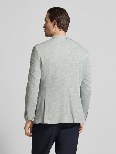 Männermodel trägt Slim Fit 2-Knopf-Sakko mit Pattentaschen von MCNEAL im hellgrauen Strukturmuster, Material-Mix, Ganzkörperansicht Rückansicht.