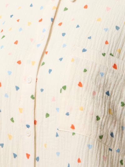 Frauenmodel trägt Relaxed Fit Pyjama-Oberteil im Allover-Look von Jake*s Casual aus reiner Baumwolle mit bunten Herzmustern, Nahaufnahme Oberkörper.