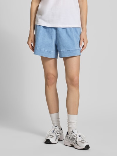 Frauenmodel trägt Wide Leg Jeansshorts aus Baumwoll-Mix Modell 'BILLO' von Pieces, Denim-Optik, mit seitlichen Eingrifftaschen, Gesäßtasche, elastischem Bundabschluss und Tunnelzug, helle Blautöne, glatte Textur, Ganzkörperansicht von vorne.