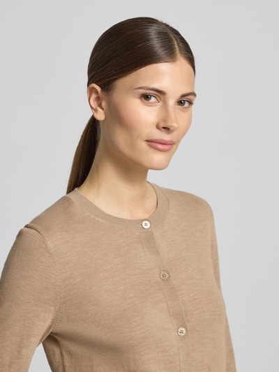Vrouwenmodel draagt Regular Fit Cardigan aus Baumwolle-Leinen-Mix van Marc O'Polo, effen beige, fijngestructureerd breisel, ronde hals, lange mouwen met gerolde zoom, enkelvoudige knoopsluiting, context: dames cardigan, katoen-linnenmix, nahaufnahme bovenlichaam.