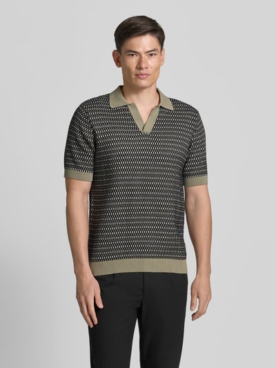 Männermodel trägt Relaxed Fit Strick-Poloshirt mit V-Ausschnitt von Lindbergh in Schwarz-Beige Allover-Look aus Reine Baumwolle, Ganzkörperansicht von vorne. Rückenlänge bei Größe M: 70 cm.