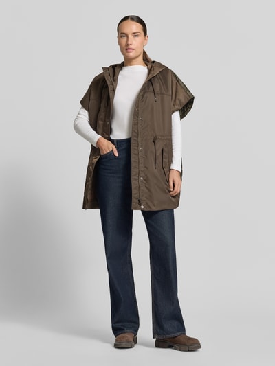 Vrouwenmodel draagt olijfgroene oversized bodywarmer met capuchon, gecombineerd met jeans, Oversized Weste mit Kapuze model 'ORIGANO' van Weekend Max Mara, full body voorkant