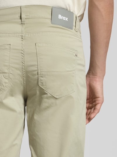 Männermodel trägt Slim Fit Stoffhose mit Lyocell-Anteil Modell 'Cadiz' von Brax, 5-Pocket-Design, Detailaufnahme Rückansicht. Elastischer Baumwoll-Mix in Beige.